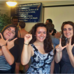 women posing with hand symbols showing WILL