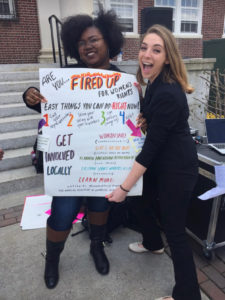 two women smiling holding flyer