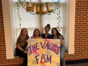 girls holding sign that says "the vagigigi fam"